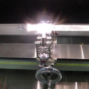 a circular, sleeved stack of rods and tubes, already drawn through the tower mechanism, is placed in a glassworking lathe to be tightened and prepared for its next round in the draw tower.