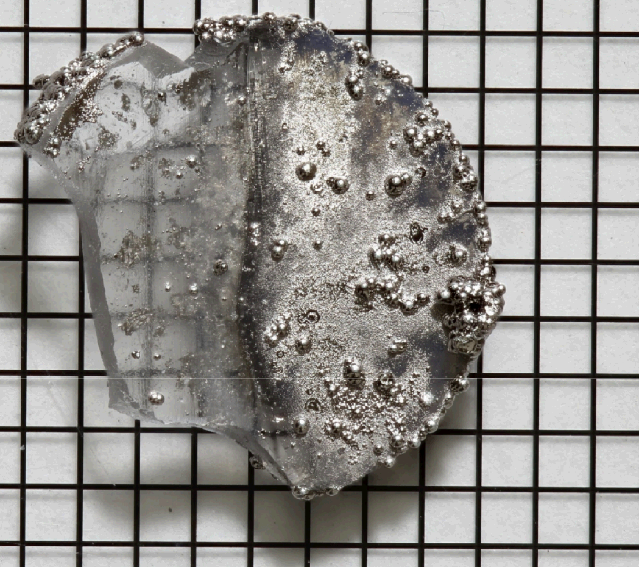 Photograph of glass sample unplated on one side (left) and plated with nickel phosphorous on the other (right)