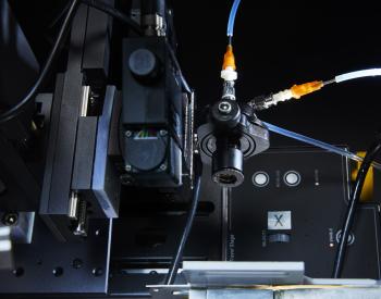 Photo of a co-axial droplet generator mounted on a motorized head capable of remote-controlled movement in the X, Y, and Z directions, as well as rotation in two planes
