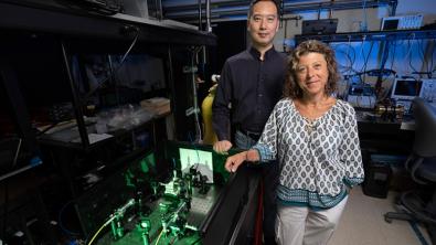 Lab photonics engineers Allan Chang and Tiziana Bond are shown with a Raman spectroscopy instrument for testing an LLNL-developed hollow-core fiber hydrogen sensor. (Photo: Blaise Douros/LLNL)