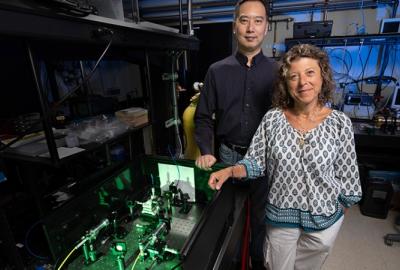 Lab photonics engineers Allan Chang and Tiziana Bond are shown with a Raman spectroscopy instrument for testing an LLNL-developed hollow-core fiber hydrogen sensor. (Photo: Blaise Douros/LLNL)