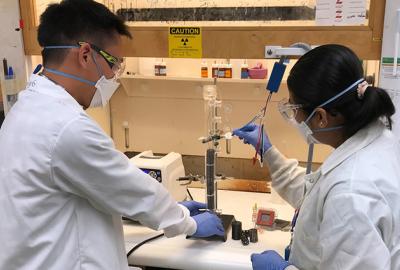 Simon Pang (left) and Buddhinie Jayathilake assemble and prepare a prototype bubble column electrobioreactor to test additively manufactured three-dimensional electrodes.