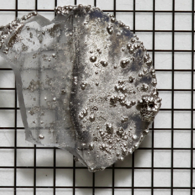 Photograph of glass sample unplated on one side (left) and plated with nickel phosphorous on the other (right)